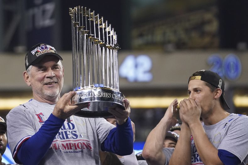 El mánager de los Rangers de Texas Bruce Bochy sostiene el trofeo de campeón de la Serie Mundial después de que el equipo superó en el juego 5 a los Diamondbacks de Arizona el miércoles 1 de noviembre del 2023. (AP Foto/Godofredo A. Vásquez)