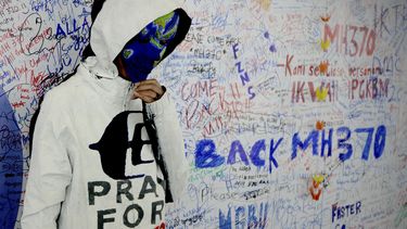 americateve | Una mujer no identificada con la cara pintada con motivos alusivos a la desaparici&oacute;n del vuelo MH370 de Malaysia Airline posa frente al "muro de la esperanza" en el aeropuerto de Kuala Lumpur en Sepang, Malasia, el lunes 17 de marzo de 20