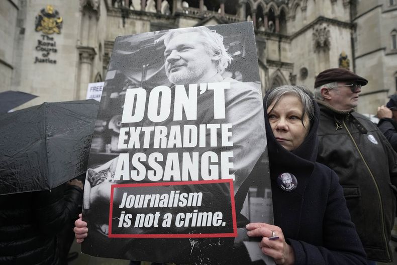 Una manifestante sostiene una pancarta frente a los Tribunales Reales de Justicia en Londres, el 21 de febrero de 2024, en apoyo al fundador de WikiLeaks, Julian Assange. (Foto AP/Kin Cheung, archivo)