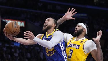 El jugador de los Warriors de Golden State Stephen Curry, a la izquierda, tira a canasta junto al jugador de los Lakers de Los Ángeles Anthony Davis en la primera mitad de su juego 4 de las semifinales de la Conferencia Oeste de la NBA el lunes 8 de mayo de 2023 en Los Ángeles. (AP Foto/Marcio Jose Sanchez)