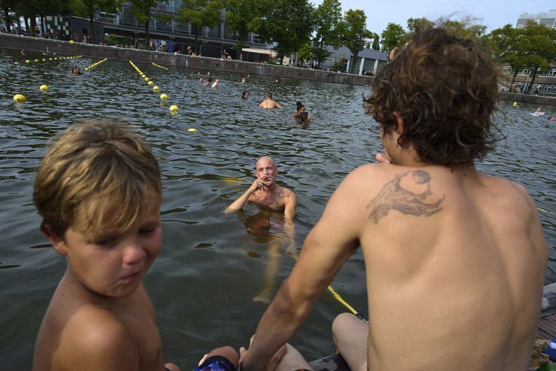 Personas nadan en una piscina cerca del Museo Marítimo en Ámsterda, Holanda, el 13 de agosto del 2025. (AP foto/Peter Dejong)