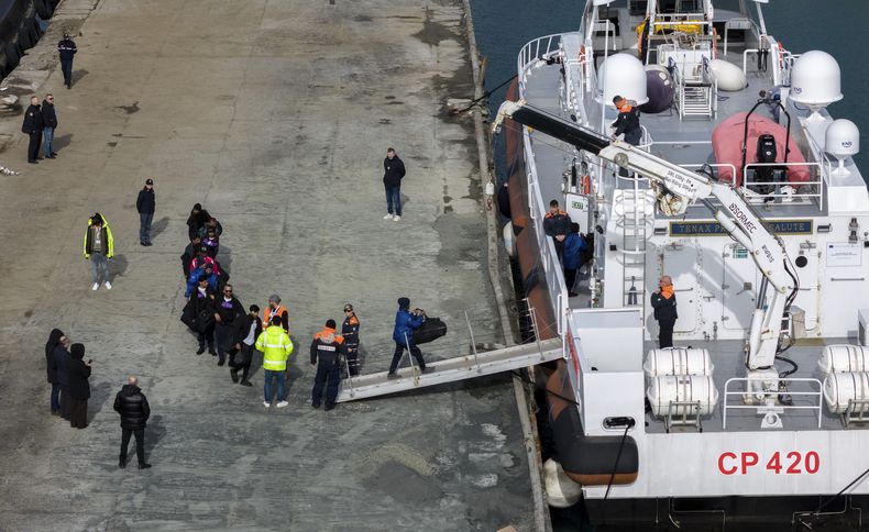 Migrantes suben a bordo de un buque de la Guardia Costera italiana como parte de una operación de traslado desde los centros de tramitación de asilo en Albania de vuelta a Italia tras una resolución de un juzgado de Roma, en el puerto de Shengjin, noroeste de Albania, sábado 1 de febrero de 2025. (AP foto/Vlasov Sulaj)