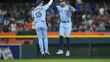 Whit Merrifield (15) y George Springer (4) celebran luego que su equipo, Azulejos de Toronto vencieran a los Tigres de Detroit, por 12-2 en Detroit. Viernes 7 de julio de 2023. (AP Foto/Paul Sancya)