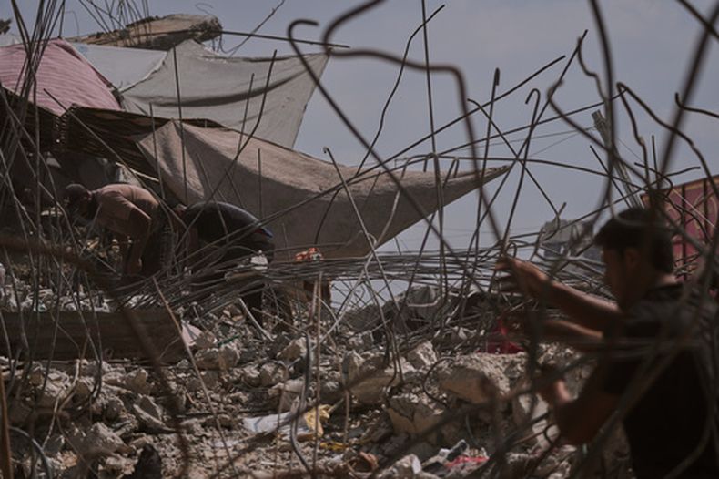 Palestinos retiran hierro de entre los escombros de edificios destruidos por bombardeos israelíes para reciclarlo, emplearlo en reparaciones o venderlo, en Ciudad de Gaza, el domingo 16 de agosto de 2026. (AP Foto/Jehad Alshrafi)