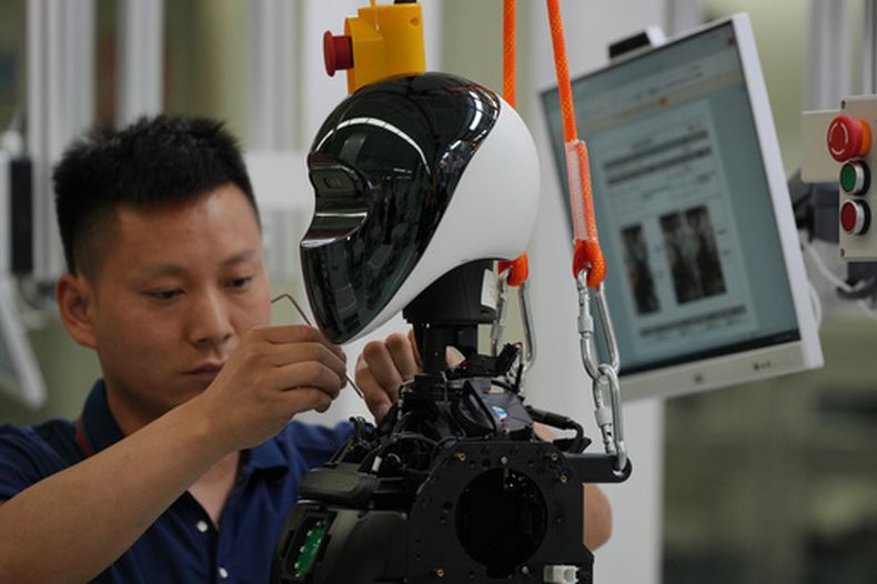 Trabajadores ensamblan un robot en la Súper Fábrica para la Inteligencia Artificial Encarnada de LY iTech, durante un recorrido de prensa, el 29 de mayo de 2026, a las afueras de Beijing. (AP Foto/Andy Wong)