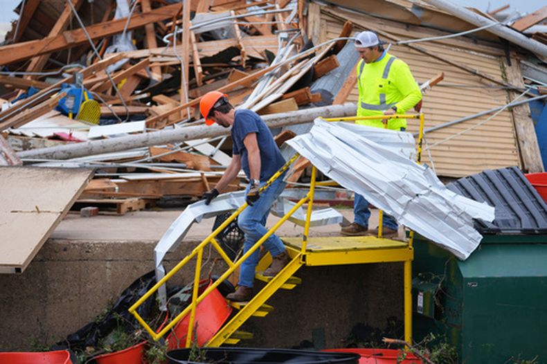 Varias personas retiran escombros tras el paso de una tormenta en Mineral Wells, Texas, el miércoles 29 de abril de 2026. (AP Foto/Julio Cortez)
