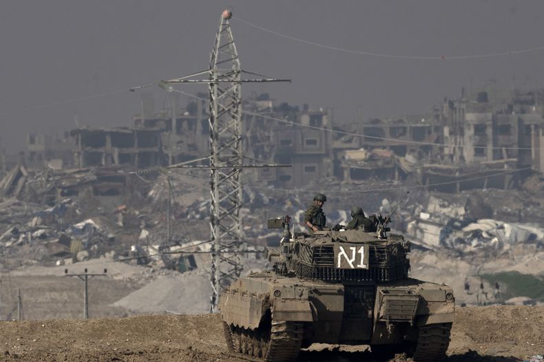 ARCHIVO - Soldados israelíes miran a la Franja de Gaza desde un tanque visto desde el sur de Israel, el viernes 19 de enero de 2024. (AP Foto/Maya Alleruzzo, Archivo)