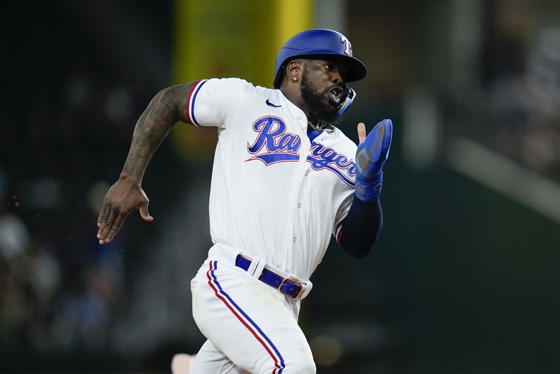 El cubano Adolis García de los Rangers de Texas corre las bases para anotar desde la primera base en un doble de Jonah Heim ante los Medias Rojas de Boston en la sexta entrada del juego. Martes 19 de septiembre de 2023, en Arlington, Texas. (AP Foto/Julio Cortez)