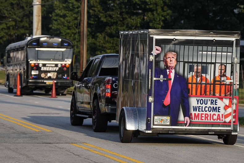 Un vehículo y un remolque pasan frente a la cárcel del condado de Fulton, el jueves 24 de agosto de 2023, en Atlanta. Está previsto la comparecencia de Trump ante las autoridades. (Foto AP/Mike Stewart)
