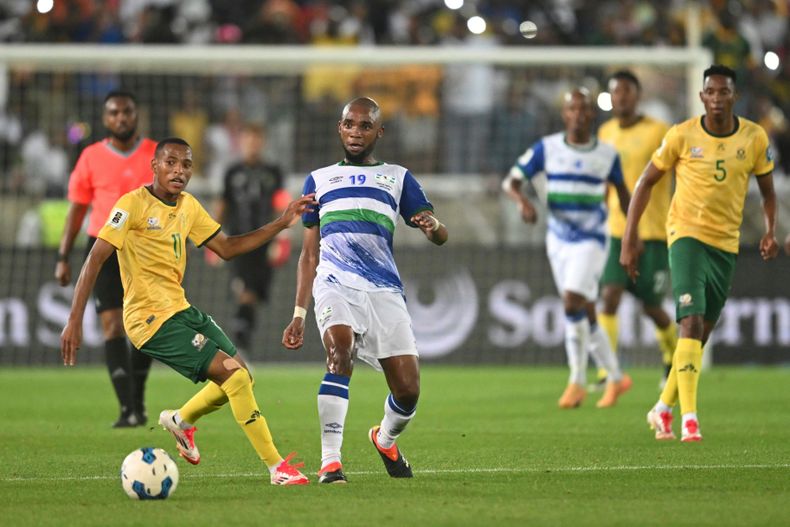 ARCHIVO - El sudafricano Relebohile Mofokeng (izquierda) pugna un balón con el lesotense Lehlohonolo Matsau en las eliminatorias del Mundial el viernes 21 de marzo de 2025, en Polokwane, Sudáfrica. (AP Foto)