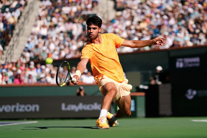 ARCHIVO - El español Carlos Alcaraz devuelve un tiro frente al ruso Daniil Medvedev durante un partido de semifinales del torneo de tenis BNP Paribas Open, el 14 de marzo de 2026, en Indian Wells, California. (Foto AP/Mark J. Terrill, archivo)