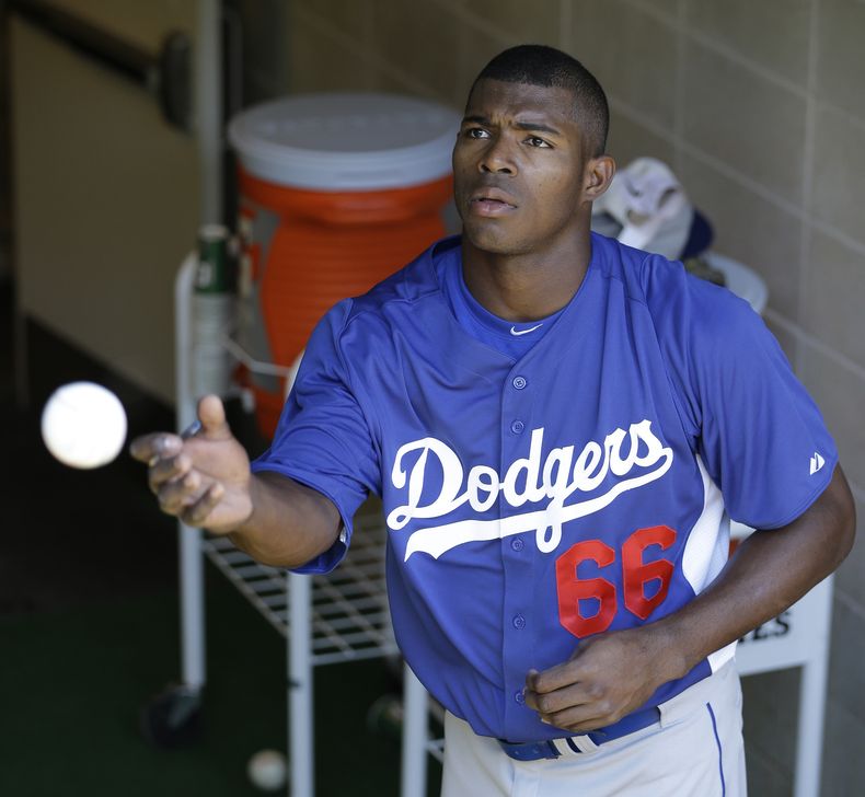 En esta foto del 19 de junio de 2013, el cubano Yasiel Puig, de los Dodgers de Los Angeles, lanza una pelota a un espectador durante un juego contra los Yanquis en Nueva York. El s&aacute;bado 28 de diciembre de 2013, Puig fue arrestado y acusado de condu