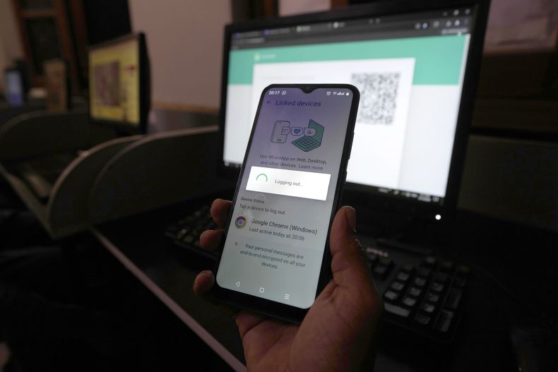 ARCHIVO -Un pakistaní espera conectar su versión móvil de WhatsApp a una computadora de escritorio con una lenta conexión a Internet que se mantuvo por varios días, en Karachi, Pakistán, el 19 de agosto de 2024. (AP Foto/Fareed Khan, Archivo)