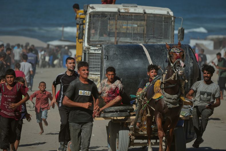 Un palestino herido por fuego de artillería israelí dirigido a un grupo de civiles que huían del norte de Gaza hacia el sur es evacuado en una carreta tirada por caballos, el miércoles 1 de octubre de 2025, en el centro de Gaza. (AP Foto/Jehad Alshrafi)