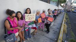 Votantes, algunos con un cartel de apoyo a la candidata presidencial de la oposición Xóchitl Gálvez, hacen fila afuera de un colegio electoral durante las elecciones generales en la Ciudad de México, el domingo 2 de junio de 2024. (AP Foto/Fernando Llano)