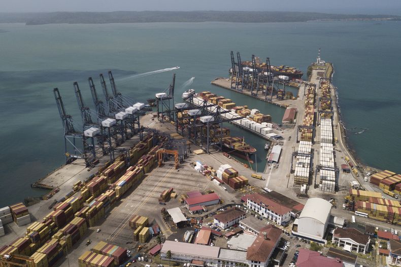 Varios contenedores permanecen apilados mientras las grúas cargan y descargan barcos de carga en el puerto Cristóbal, operado por Panama Ports Company, en Colón, Panamá, el martes 4 de febrero de 2025. (AP Foto/Matias Delacroix)