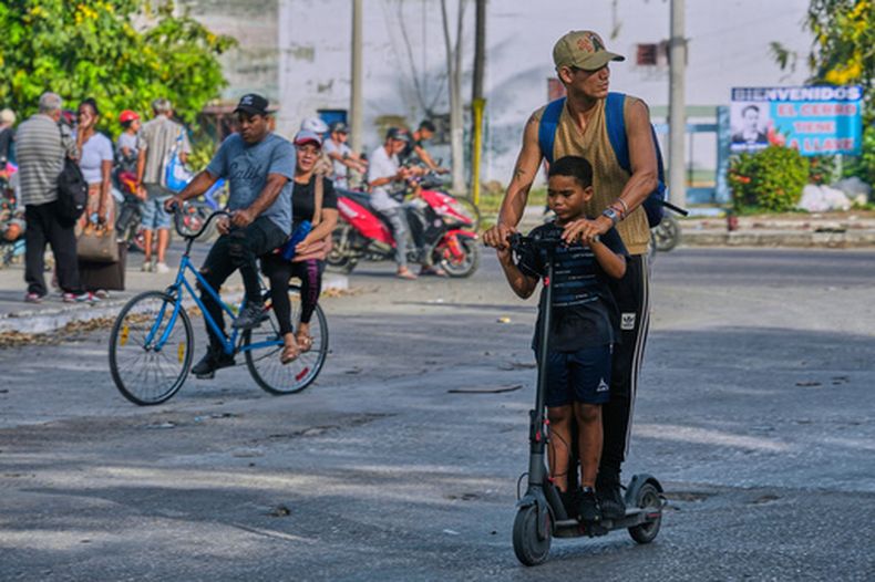 Unas personas circulan en patinete eléctrico y en bicicleta por La Habana, Cuba, el viernes 8 de mayo de 2026. (Foto AP/Ramón Espinosa)