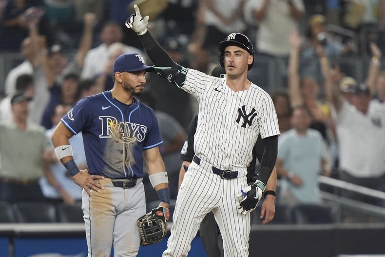 El campocorto de los Rays de Tampa Bay, José Caballero, observa mientras Cody Bellinger de los Yankees de Nueva York gesticula a sus compañeros después de batear un triple productor de carrera durante la décima entrada de un partido de béisbol el miércoles 30 de julio de 2025, en Nueva York. (AP Photo/Frank Franklin II)