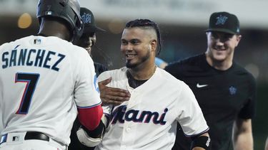 Luis Arráez (3), de los Marlins de Miami, es felicitado por sus compañeros de equipo después de producir la carrera de la victoria en el juego de béisbol en contra de los Rockies de Colorado, en 10 entradas, el domingo 23 de julio de 2023, en Miami. Los Marlins derrotaron 3-2 a los Rockies. (AP Foto/Marta Lavandier)