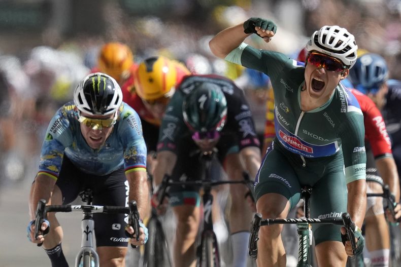 Jasper Philipsen, de Bélgica, celebra mientras cruza la meta al final de la etapa siete del Tour de Francia, después de un recorrido de 170 kilómetros (105.5 millas) con arrancada en Mont-de-Marsan y meta en Burdeos, Francia, el viernes 7 de julio de 2023. El británico Mark Cavendish, izquierda, terminó segundo. (AP Foto/Thibault Camus)