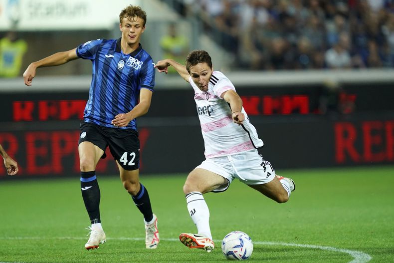 Federico Chiesa (derecha) de la Juventus se prepara para hacer un disparo delante de Giorgio Scalvini del Atalanta, durante el partido en el Gewiss Stadium, en Bérgamo, Italia. Domingo 1 de octubre de 2023. (Spada/LaPresse via AP)