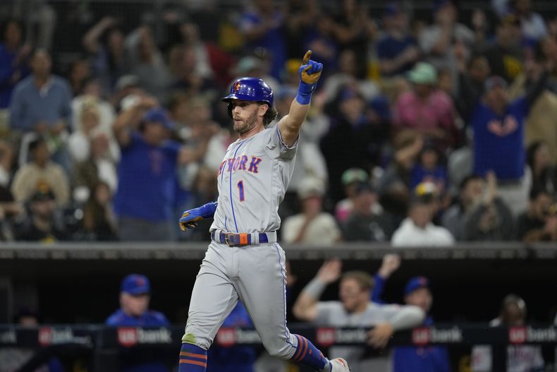 Jeff McNeil de los Mets de Nueva York luego de anotar en un sencillo de Francisco Álvarez durante la 10ma entrada en el juego de las Grandes Ligas contra los Padres de San Diego, el viernes 7 de julio de 2023, en San Diego. (AP Foto/Gregory Bull)