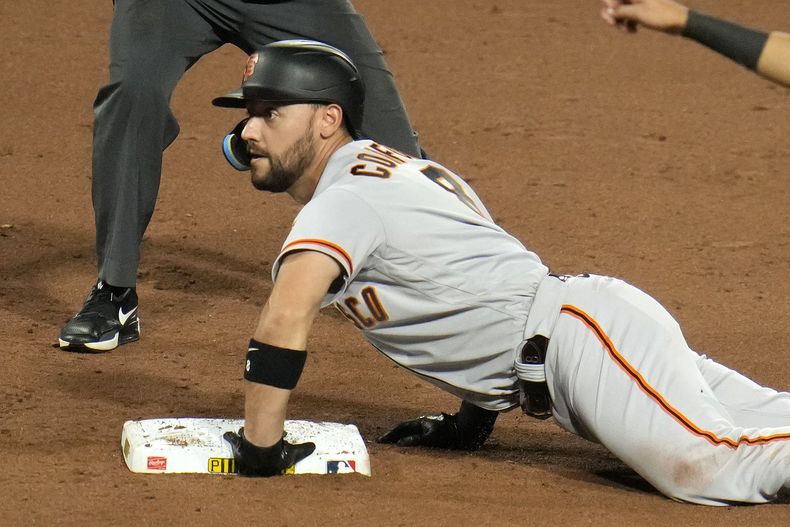 Michael Conforto, de los Gigantes de San Francisco, se desliza en la intermedia luego de empujar dos carreras con un hit ante los Piratas de Pittsburgh, el sábado 15 de julio de 2023 (AP Foto/Gene J. Puskar)