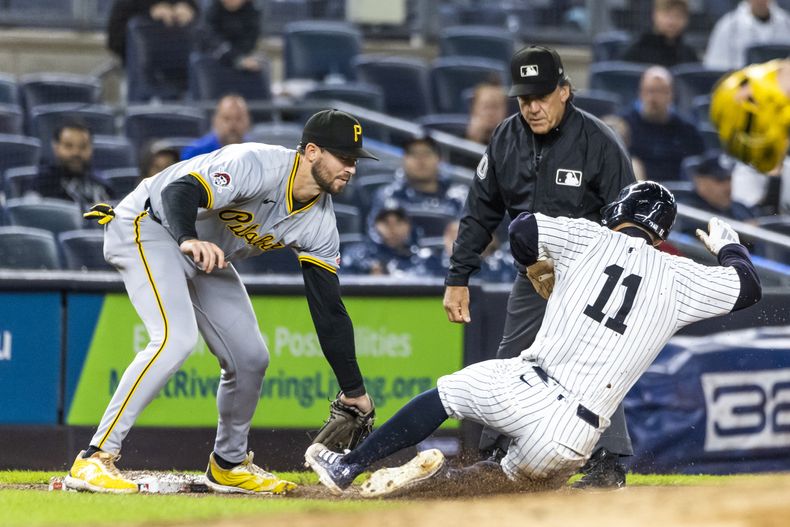 Anthony Volpe (11) de los Yankees de Nueva York es puesto fuera en tercera por el antesalista de los Piratas de Pittsburgh, Jared Triolo (izquierda), durante la séptima entrada del juego de béisbol, el domingo 29 de septiembre, en Nueva York. (AP Foto/Eduardo Munoz Alvarez)