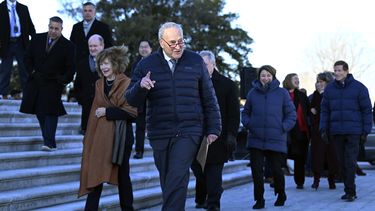 El líder de la minoría demócrata en el Senado, Chuck Schumer, camina a un costado de la escalinata del Capitolio federal junto a otras personas, el jueves 9 de enero de 2025, en Washington. (AP Foto/John McDonnell)
