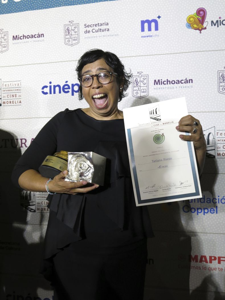 La directora mexico-salvadoreña Tatiana Huezo posa con los premios de mejor largometraje documental mexicano de una directora mujer, mejor largometraje documental y el premio del público a mejor largometraje documental por El eco en el Festival Internacional de Cine de Morelia, el viernes 27 de octubre de 2023, en Morelia, México. (Foto AP/Berenice Bautista)