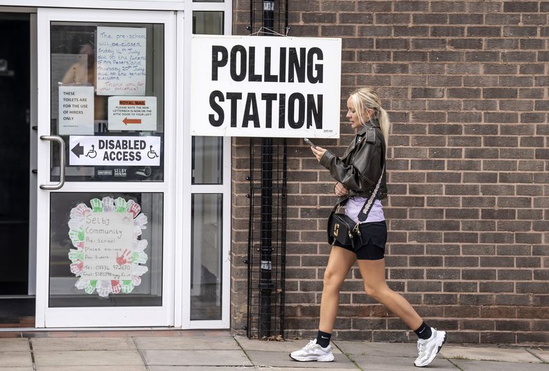Una mujer pasa frente a un cartel de votación el Centro Comunitario de Selby, North Yorkshire, en la elección especial del distrito debido a la renuncia del parlamentario Nigel Adams, jueves 20 de julio de 2023. Ha comenzado la votación en tres elecciones especiales, en las que los conservadores gobernantes temen sufrir derrotas. (Danny Lawson/PA via AP)
