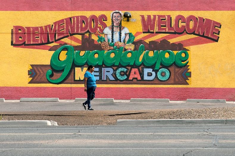 Una persona pasa junto a un mural el 19 de mayo de 2026, el cual promociona Guadalupe, Arizona. (AP Foto/Ross D. Franklin)