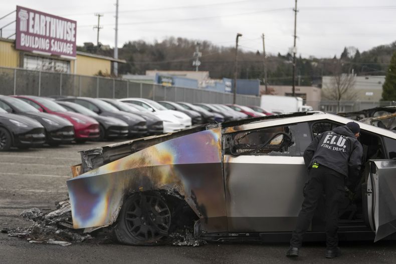 ARCHIVO - Un miembro del departamento de bomberos de Seattle inspecciona un Tesla Cybertruck en un estacionamiento de Tesla en Seattle, el lunes 10 de marzo de 2025. (AP Foto/Lindsey Wasson, Archivo)