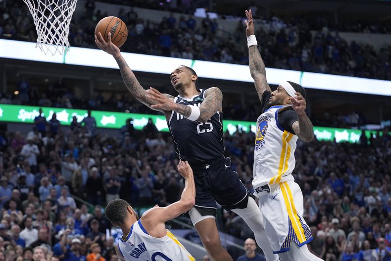P.J. Washington (25), de los Mavericks de Dallas, ataca la canasta ente las marcas defensivas de Stephen Curry (30) y Gary Payton II (0) durante la segunda mitad del juego de baloncesto de la NBA en Dallas, en viernes 5 de abril de 2024. A Curry le marcaron una falta en la jugada. (AP Foto/LM Otero)