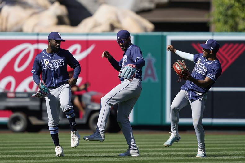 El zurdo cuban de los Rays de Tampa Bay Randy Arozarena y los jardineros Jose Siric y Richie Palacios celebran la victoria de su equipo ante los Angelinos de Los Ángeles el miércoles 10 de abril del 2024. (AP Foto/Ryan Sun)
