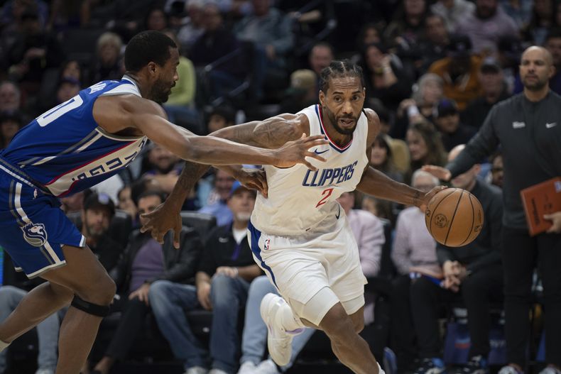 Kawhi Leonard (2), de los Clippers de Los Ángeles, trata de rebasar a Harrison Barnes (40), de los Kings de Sacramento, en el primer cuarto del juego de la NBA que enfrentó a ambos equipos en Sacramento, California, el 29 de noviembre de 2023. (AP Foto/José Luis Villegas)