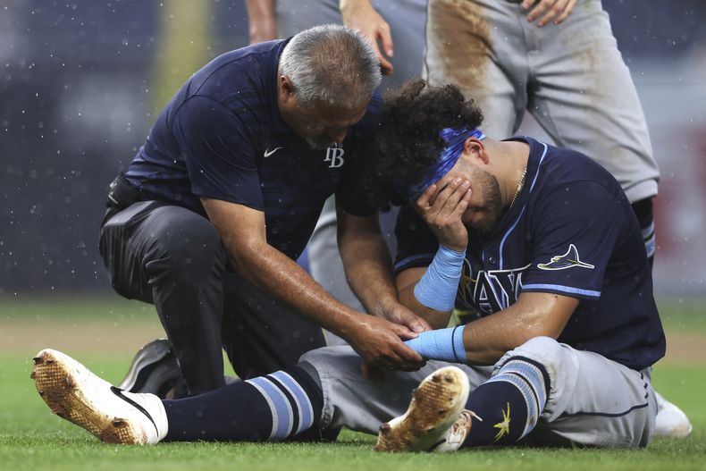 Jonathan Aranda (62) de los Rays de Tampa Bay es atendido después de lesionarse en la quinta entrada de un partido de béisbol contra los Yankees de Nueva York, el jueves 31 de julio de 2025, en Nueva York. (AP Photo/Heather Khalifa)