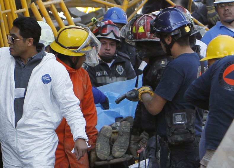 Socorristas trasladan a un trabajador de la construcci&oacute;n que falleci&oacute; por el colapso de un edificio en Ciudad de M&eacute;xico, el s&aacute;bado 4 de enero de 2014. Al menos una persona muri&oacute; y 20 resultaron heridos durante la constru