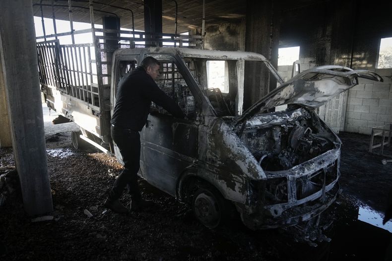 Mohammed Hanani mira su auto quemado tras un ataque de colonos en el que se dañaron vehículos y casas en el poblado de Beit Furik, en la ciudad de Nablus, en la Cisjordania ocupada, el miércoles 4 de diciembre de 2024. (AP Foto/Majdi Mohammed)