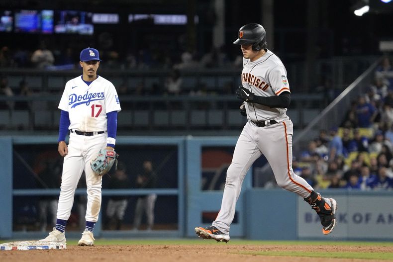 Wilmer Flores (derecha), de los Gigantes de San Francisco, corre las bases tras sacudir un bambinazo de dos carreras, ante la mirada del segunda base de los Dodgers de Los Ángeles Miguel Vargas, en el séptimo inning del juego de la MLB que enfrentó a ambos equipos, el 16 de junio de 2023, en Los Ángeles. (AP Foto/Mark J. Terrill)