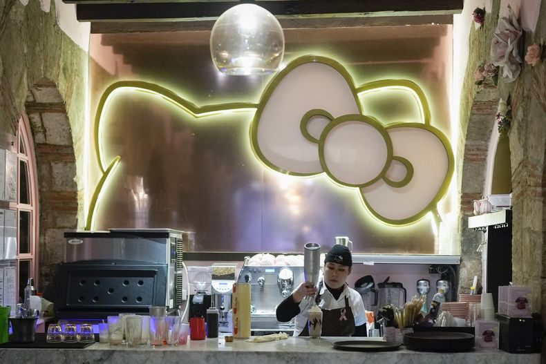 Una empleada de un café con temática de Hello Kitty prepara una bebida para fans del personaje japonés, en la Ciudad de México, el jueves 10 de octubre de 2024. (Foto AP/Eduardo Verdugo)