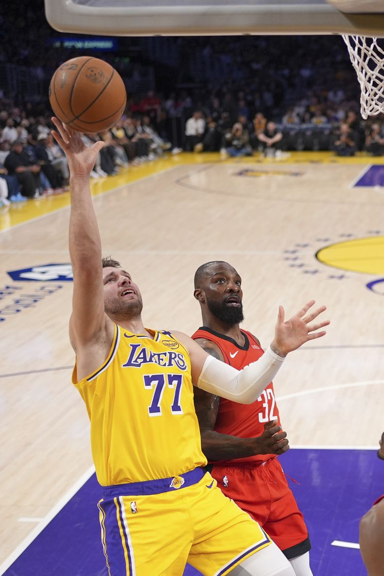 El esloveno Luka Doncic, de los Lakers de Los Ángeles, dispara frente a Jeff Green, de los Rockets de Houston, el viernes 11 de abril de 2025 (AP Foto/Mark J. Terrill)
