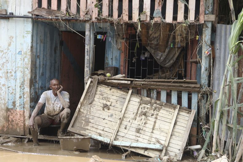 Un hombre descansa en la entrada de su casa afectada por las inundaciones de Esmeraldas, Ecuador, el lunes 5 de junio de 2023. La provincia costera de Esmeraldas se inundó el domingo tras 12 horas de continuas lluvias que provocaron evacuaciones por el desbordamiento de seis ríos. (AP Foto/César Muñoz)