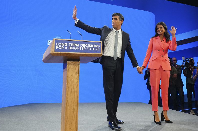 El primer ministro británico Rishi Sunak y su esposa Akshata Murty saludan después del discurso de él en la conferencia anual del Partido Conservador en Manchester, Inglaterra, miércoles 4 de octubre de 2023. (AP Foto/Jon Super)