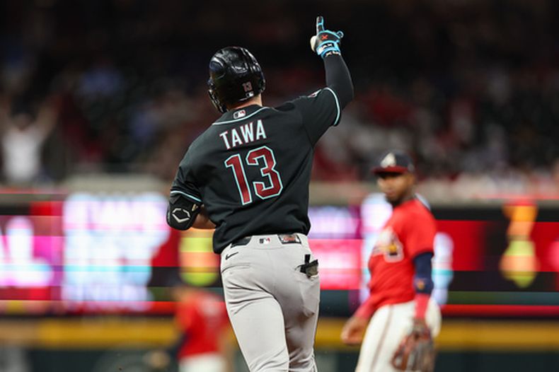 Tim Tawa (13), de los Diamondbacks de Arizona, celebra mientras recorre las bases después de batear un cuadrangular solitario durante la novena entrada del juego de béisbol de Grandes Ligas, el viernes 14 de agosto de 2026, en Atlanta. (AP Foto/Colin Hubbard)