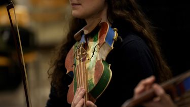 Una integrante de la Orquesta del Mar ensaya con un violín hecho con madera de barcos de inmigrantes en Milán, en el norte de Italia el sábado 10 de febrero de 2024. Reclusos de la prisión Opera de máxima seguridad usan la madera de los botes de inmigrantes para crear instrumentos musicales que la Orquesta del Mar tocó en su debut en el Teatro alla Scala (Foto AP/Antonio Calanni)