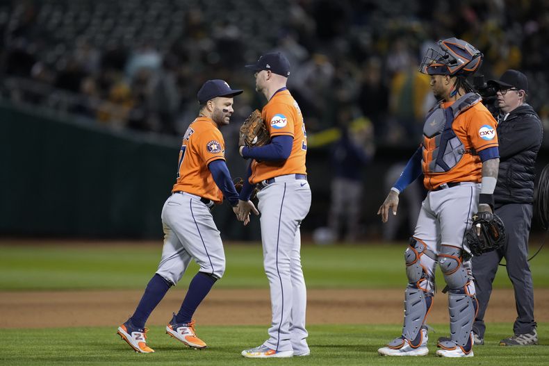 El venezolano José Altuve (izquierda), festeja con Ryan Pressly, su compañero en los Astros de Houston, tras la victoria sobre los Atléticos de Oakland, el viernes 26 de mayo de 2023 (AP Foto/Godofredo A. Vásquez)