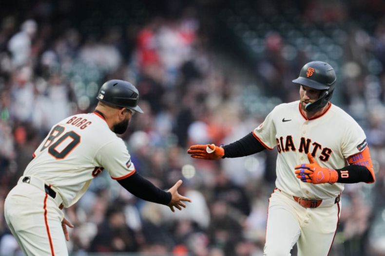 Casey Schmitt, derecha, de los Gigantes de San Francisco, celebra con el coach de tercera, Héctor Borg, después de batear un cuadrangular solitario durante la primera entrada del juego de béisbol de Grandes Ligas contra los Padres de San Diego, el lunes 4 de mayo de 2026, en San Francisco. (AP Foto/Godofredo A. Vásquez)