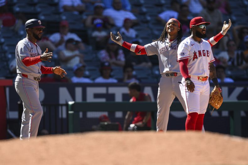 CJ Abrams, centro, de los Nacionales de Washington, celebra después de batear un triple productor durante la 11ma entrada del juego de béisbol de Grandes Ligas frente a los Angelinos de Los Ángeles, el domingo 29 de junio de 2025, en Anaheim, California. (AP Foto/William Liang)