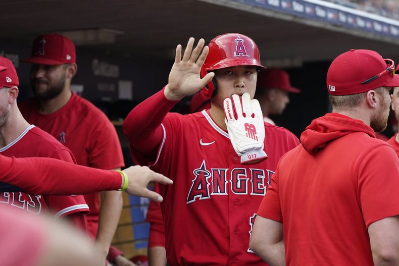 Shohei Ohtani, de los Angelinos de Los Ángeles, festeja en la cueva luego de anotar una carrera en el juego del martes 25 de julio de 2023, ante los Tigres de Detroit (AP Foto/Carlos Osorio)